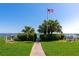 Community lawn area with benches and picnic tables overlooking water with view of American flag at 2955 N Beach Rd # A422, Englewood, FL 34223