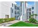 Modern white condo building with balconies, lush landscaping, and well-maintained grounds at 2955 N Beach Rd # A422, Englewood, FL 34223