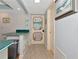 Hallway featuring tiled floors and decorative painting on the main door leading outside the home at 2955 N Beach Rd # A422, Englewood, FL 34223