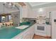 Well-lit kitchen featuring a white range and microwave with blue backsplash and teal countertops at 2955 N Beach Rd # A422, Englewood, FL 34223