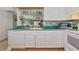 Bright kitchen with white cabinetry, countertops, and stainless steel appliances overlooking the living area at 2955 N Beach Rd # A422, Englewood, FL 34223