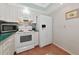 Efficient kitchen with white appliances, bright lighting, and light-colored countertops and cabinets at 2955 N Beach Rd # A422, Englewood, FL 34223