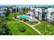 Aerial view of a community pool surrounded by lush lawns, walking paths, and tropical foliage at 2955 N Beach Rd # A422, Englewood, FL 34223