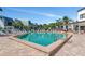 Outdoor pool surrounded by lounge chairs, palm trees, and modern buildings under a clear blue sky at 2955 N Beach Rd # A422, Englewood, FL 34223