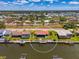 Drone shot of a home on a canal with a private boat dock, surrounded by lush greenery, and clear waterways at 322 Oakwood Cir, Englewood, FL 34223