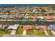 Aerial view showcasing a waterfront home with a red tile roof, surrounded by lush landscaping and a private canal at 322 Oakwood Cir, Englewood, FL 34223