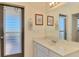 Bathroom with white vanity, framed art, and glass block window at 322 Oakwood Cir, Englewood, FL 34223
