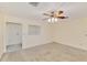 Bedroom with neutral carpet, ceiling fan, and a window allowing ample natural light at 322 Oakwood Cir, Englewood, FL 34223