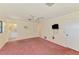 Bedroom with soft pink carpet, tv, and ensuite bathroom at 322 Oakwood Cir, Englewood, FL 34223