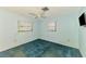 Bedroom featuring an outdated turquoise carpet and two windows at 322 Oakwood Cir, Englewood, FL 34223