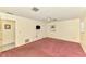 Bedroom with soft pink carpet, tv, and natural lighting from window at 322 Oakwood Cir, Englewood, FL 34223