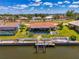A waterfront home features a private dock and lush lawn leading to the waterway at 322 Oakwood Cir, Englewood, FL 34223