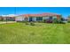 A well-maintained home with a red tile roof, lush green lawn and a beautifully landscaped yard at 322 Oakwood Cir, Englewood, FL 34223