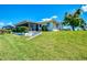 Well-maintained home exterior with a lush green lawn and mature tree at 322 Oakwood Cir, Englewood, FL 34223
