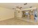 Spacious living room with ceiling fan, transitioning to the kitchen with tile flooring at 322 Oakwood Cir, Englewood, FL 34223