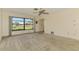 Bright living room featuring large window, neutral paint colors, and plush carpeting at 322 Oakwood Cir, Englewood, FL 34223