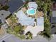 Aerial view of a house and backyard featuring a pool, patio, and driveway with lush landscaping at 337 Harbor S Dr, Venice, FL 34285