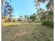Expansive backyard with lush lawn, mature trees, and a covered patio with swimming pool at 337 Harbor S Dr, Venice, FL 34285