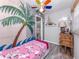 Charming bedroom with a colorful palm tree mural, ceiling fan, and natural light at 337 Harbor S Dr, Venice, FL 34285