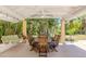 Outdoor patio features a dining area and porch swing surrounded by lush, mature landscaping at 337 Harbor S Dr, Venice, FL 34285