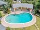 Aerial view of a kidney-shaped swimming pool with a built-in ladder and sun deck, plus an adjacent covered outdoor living space at 337 Harbor S Dr, Venice, FL 34285