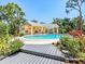 Beautiful pool area with a covered patio for lounging, surrounded by lush tropical landscaping at 337 Harbor S Dr, Venice, FL 34285