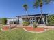 Relaxing backyard featuring a covered patio with seating, a hot tub and lush landscaping with palm trees at 379 Harbor Isles Dr, North Port, FL 34287