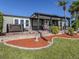 Backyard featuring a relaxing hot tub and covered patio area with plenty of seating and lush landscaping at 379 Harbor Isles Dr, North Port, FL 34287
