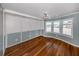 Sunlit bedroom features hardwood floors and large windows with pleasant neighborhood views at 379 Harbor Isles Dr, North Port, FL 34287