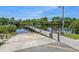 Community boat ramp with adjacent wooden dock on a serene waterway with boat access, and lush greenery at 379 Harbor Isles Dr, North Port, FL 34287