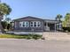 Charming home featuring well-maintained landscaping, a covered carport and gray siding for a polished look at 379 Harbor Isles Dr, North Port, FL 34287