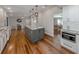Open-concept kitchen with white cabinets, granite countertops, stainless steel appliances, and hardwood floors at 379 Harbor Isles Dr, North Port, FL 34287