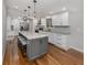 Stylish kitchen boasts white cabinetry, stainless steel appliances, granite counters, and a center island with seating at 379 Harbor Isles Dr, North Port, FL 34287