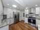 Well-lit kitchen featuring white cabinets, stainless steel appliances, granite countertops and hardwood floors at 379 Harbor Isles Dr, North Port, FL 34287