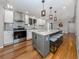Modern kitchen with a large island, granite countertops, stainless steel appliances, and hardwood floors at 379 Harbor Isles Dr, North Port, FL 34287