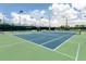 Well-maintained tennis court with green and blue surfaces and professional lighting for evening play at 379 Harbor Isles Dr, North Port, FL 34287