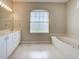 Bathroom with dual sinks, tub, and large window at 4062 Green Tree Ave, Sarasota, FL 34233