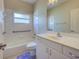 Bright bathroom with white tile, grab bars, and updated vanity, offering safety and style at 4062 Green Tree Ave, Sarasota, FL 34233