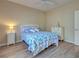 Bright bedroom with light wood floors, ceiling fan and nautical themed blue and white bedding at 4062 Green Tree Ave, Sarasota, FL 34233