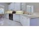 Well-lit kitchen featuring white cabinets, tile flooring and stainless steel appliances at 4062 Green Tree Ave, Sarasota, FL 34233