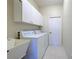 Functional laundry room features a utility sink, washer, dryer, and ample cabinet space at 4062 Green Tree Ave, Sarasota, FL 34233