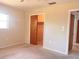A bedroom has neutral walls, carpet flooring, a window and a closet with a wooden door at 407 Bahama Rd, Venice, FL 34293