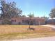 Charming single-story home with red shutters, manicured lawn and mature trees providing ample shade at 407 Bahama Rd, Venice, FL 34293