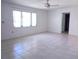 Bright living room featuring tile floors, a ceiling fan, and a large window for ample natural light at 407 Bahama Rd, Venice, FL 34293