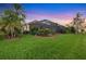 Lush backyard featuring green grass, landscaping, and a screened-in patio at 4326 Corso Venetia Blvd, Venice, FL 34293