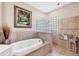 Elegant bathroom featuring a soaking tub, glass block window, and decorative tile work at 4326 Corso Venetia Blvd, Venice, FL 34293