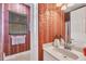 Inviting bathroom with red patterned wallpaper, and a vanity with ample lighting at 4326 Corso Venetia Blvd, Venice, FL 34293