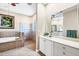 Luxurious bathroom with a soaking tub, tiled shower, and vanity with plenty of counter space at 4326 Corso Venetia Blvd, Venice, FL 34293