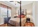 Bedroom boasts a classic four-poster bed, hardwood floors, and bright window at 4326 Corso Venetia Blvd, Venice, FL 34293