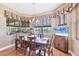 Cozy dining room with a charming chandelier and a picturesque view of the lake at 4326 Corso Venetia Blvd, Venice, FL 34293